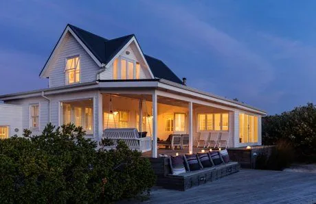 A family home at dusk with its outdoor and verandah lighting on